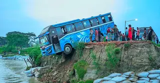 মানিকগঞ্জে নিয়ন্ত্রণ হারিয়ে নদীর পাড়ে ঝুলে পড়লো যাত্রীবাহী বাস